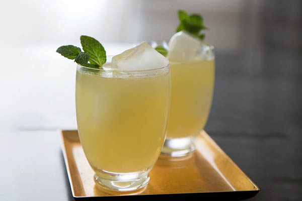 Холодный коктейль с медом и лимоном поданный на подносе.