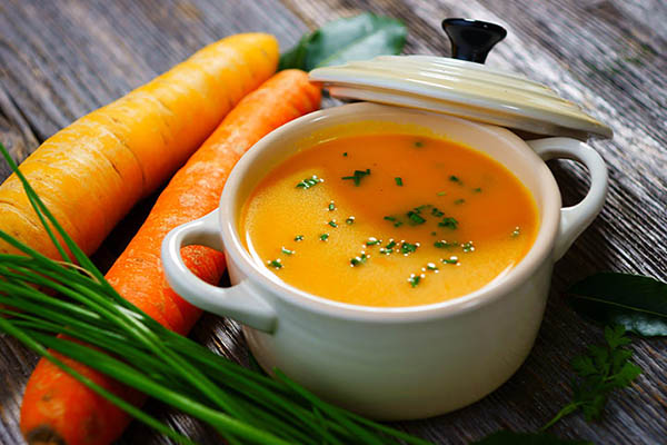 Морковный суп-пюре с медом, аппетитная композиция с кастрюлькой и свежей морковью