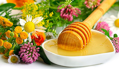 Цветочный мед в пиале рядом с полевыми цветами